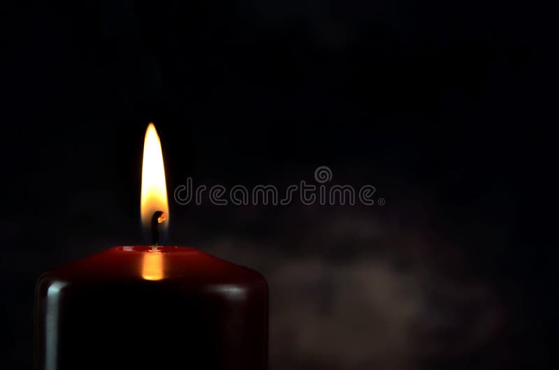 Burning Single Red Candle with Dancing Flame on the Dark Background