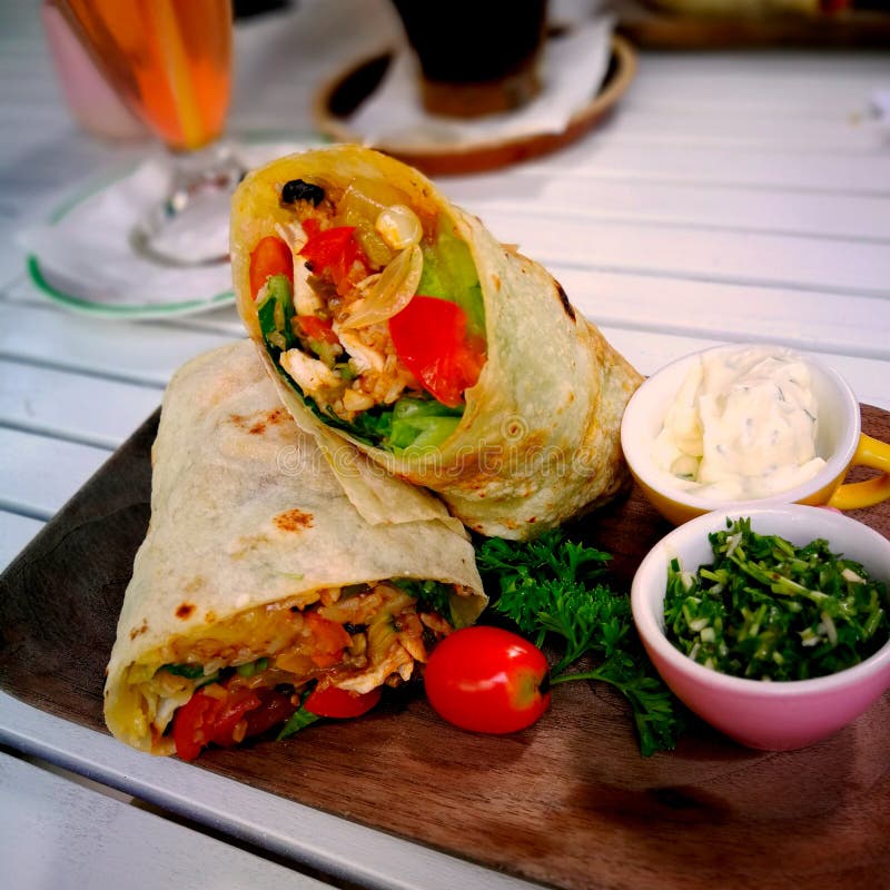 Burrito opakunki z wołowiną i warzywami na drewnianym prostokątnym talerzu Wo?owiny burrito, meksyka?ski jedzenie obraz royalty free Burrito opakunki z wołowiną i warzywami na drewnianym prostokątnym talerzu Wo?owiny burrito, meksyka?ski jedzenie obraz royalty free