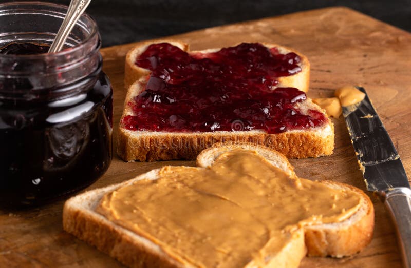 Burro di arachidi e Jelly Sandwich su un contatore di cucina di legno fotografie stock Burro di arachidi e Jelly Sandwich su un contatore di cucina di legno fotografie stock