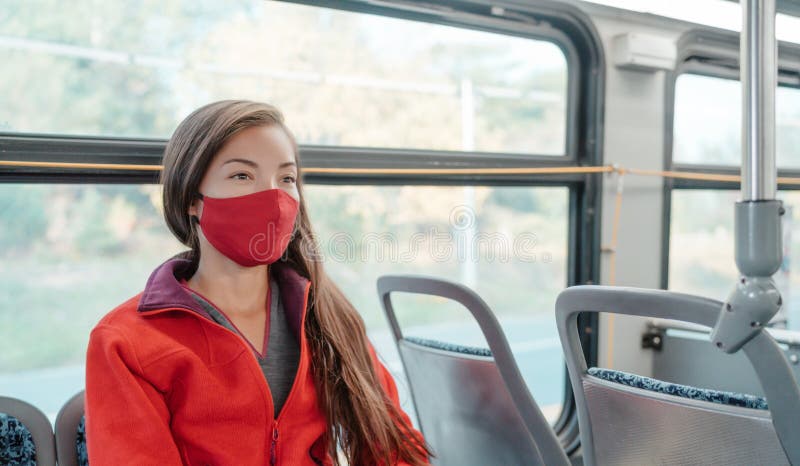 Bus travel during coronavirus. Asian woman commuter wearing mask riding public transport commuting as prevention. Safety royalty free stock photography Bus travel during coronavirus. Asian woman commuter wearing mask riding public transport commuting as prevention. Safety royalty free stock photography