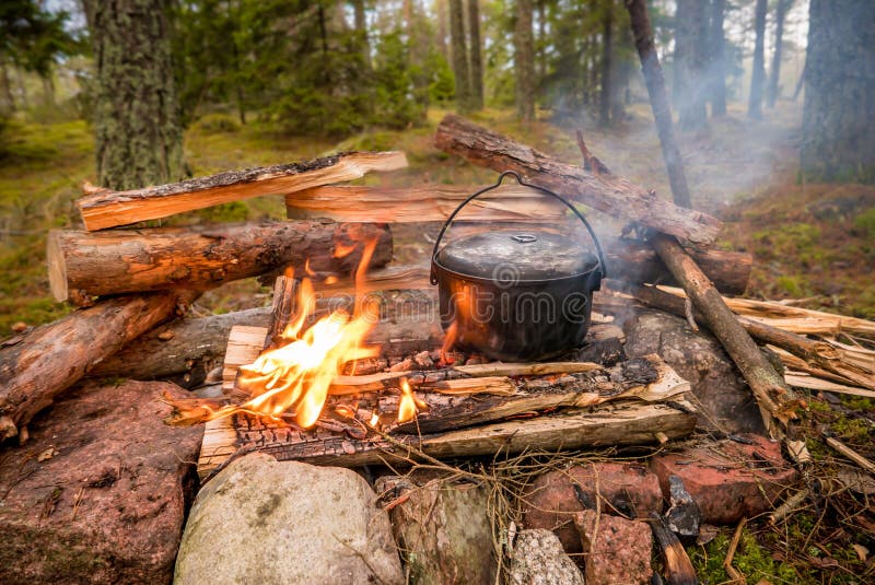 Bushcraft Setting with a Camping Pot on a Burning Fire. Stock Image