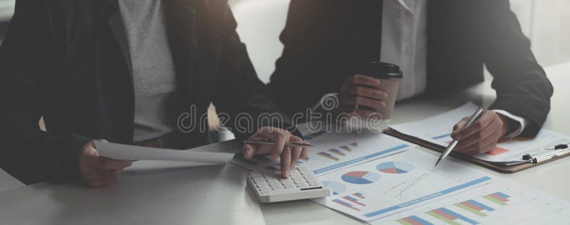Business analyst pointing to earnings charts and graphs. Analysts are calculating the numbers with a calculator for good future royalty free stock photography