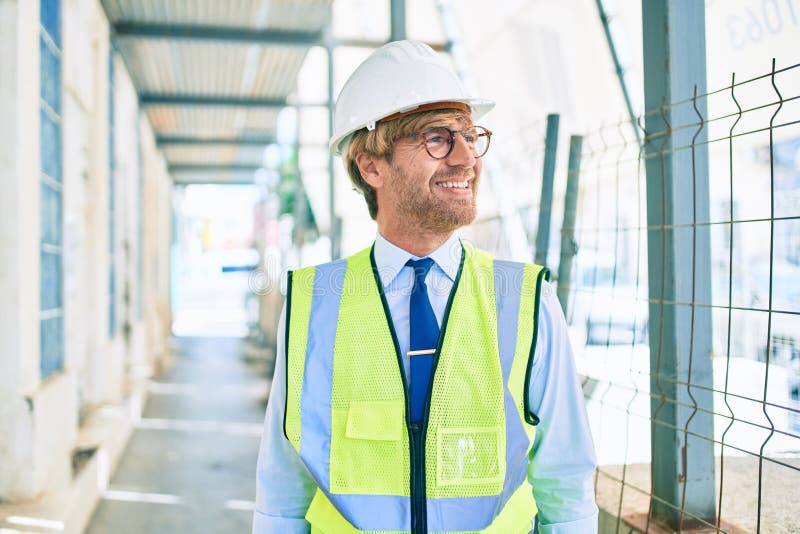 Business architect man wearing hardhat standing outdoors of a building project wearing reflective vest stock photos
