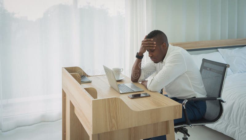 Business black american man, African person working from home, thinking about problem with computer notebook laptop and suffering from depression in quarantine in corona virus pandemic concept