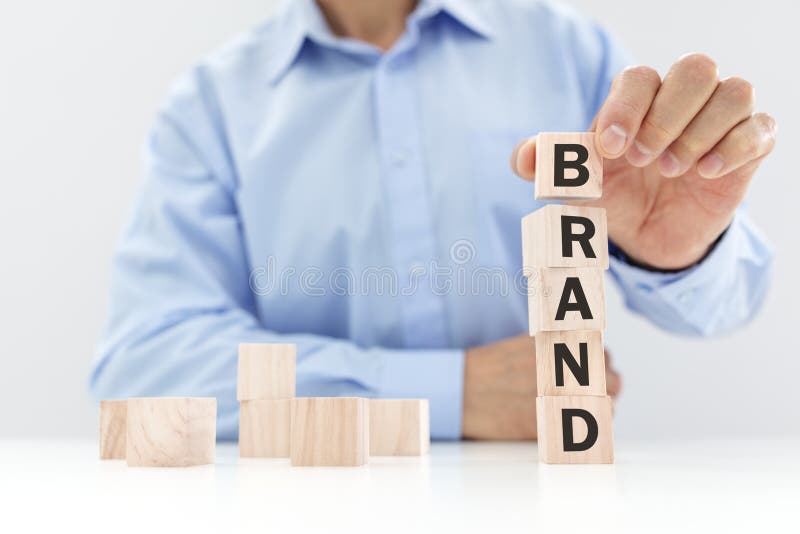 Business brand building or branding for company identity and marketing. Businessman stacking wood cube blocks with letters