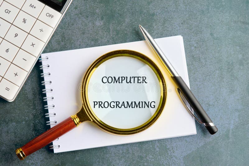 Business concept. Words COMPUTER PROGRAMMING in a clean notebook on a gray background, top view royalty free stock image