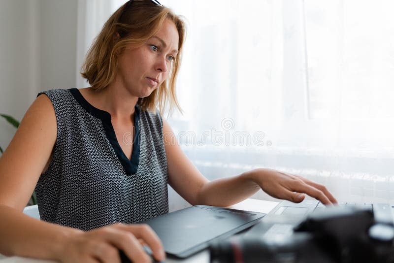 Business and creativity. A young woman is working intently at the computer.Near the camera and tablet
