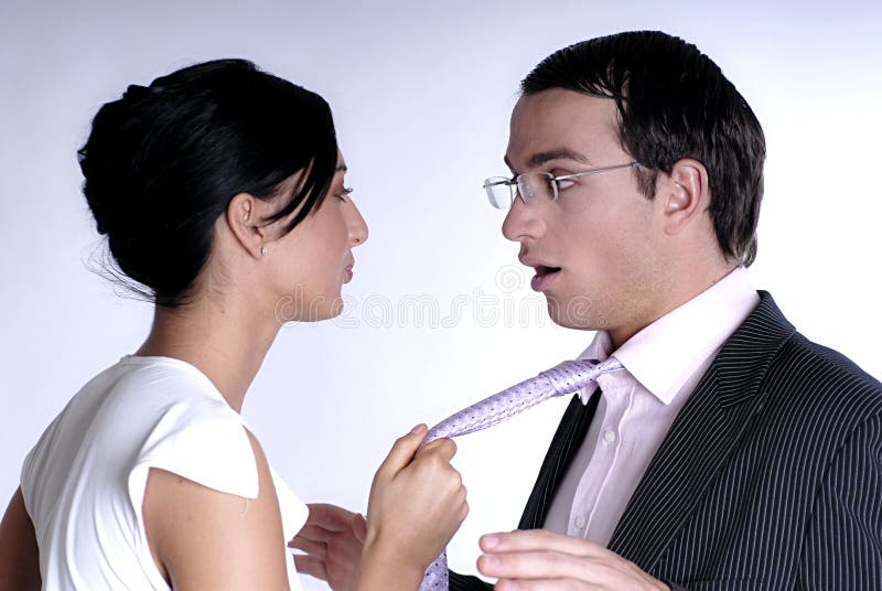 Una foto de de pie una mujer posesión atar a dominante a través de hombre sorprendido de acuerdo a su acción, ambos la tienda Vestido.