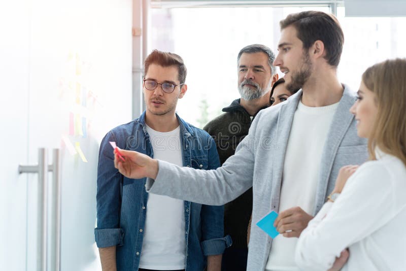 Business, education and office concept - business team with flip board in office discussing something royalty free stock image Business, education and office concept - business team with flip board in office discussing something royalty free stock image