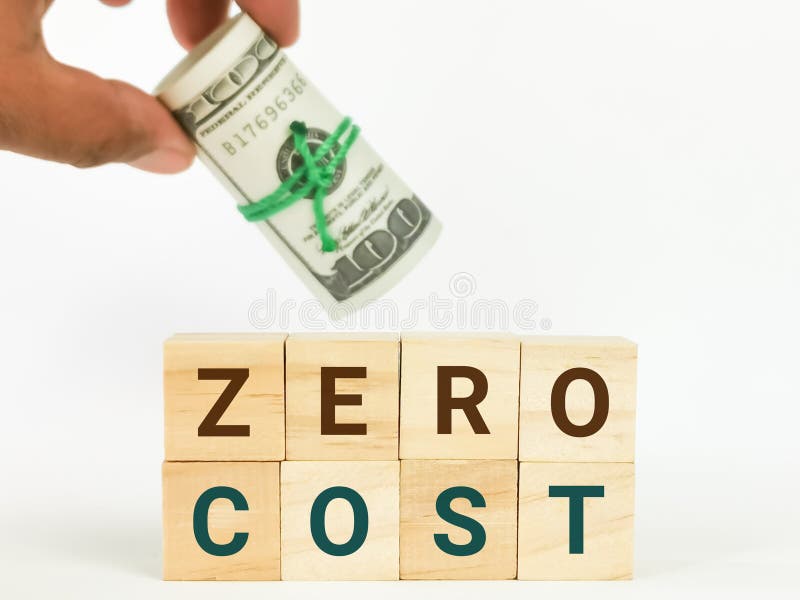 Text zero cost wooden cubes against white background with blurry image hand holding dollar bills. stock images