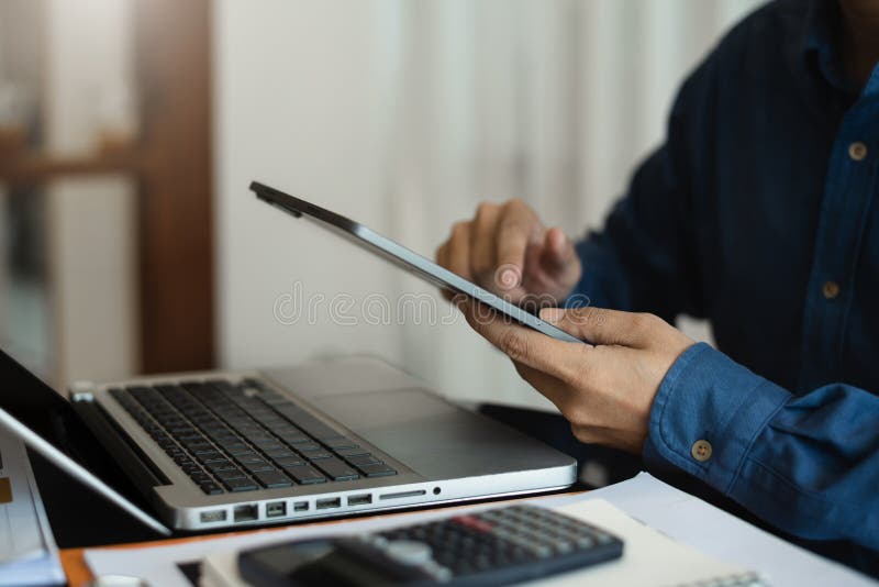 Business and financial concepts about office work. Analysts discuss business with a tablet and calculator as a tool.