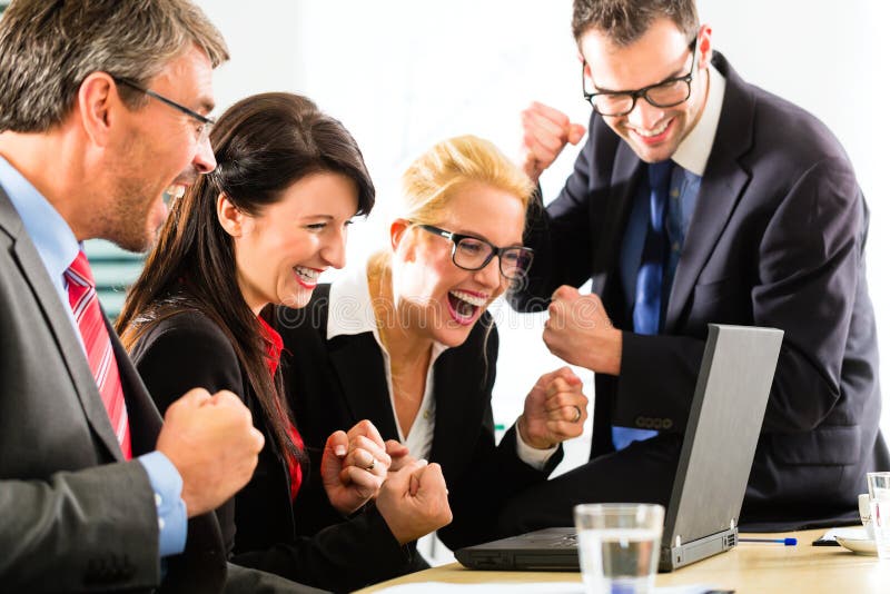 Business people looking at laptop with success