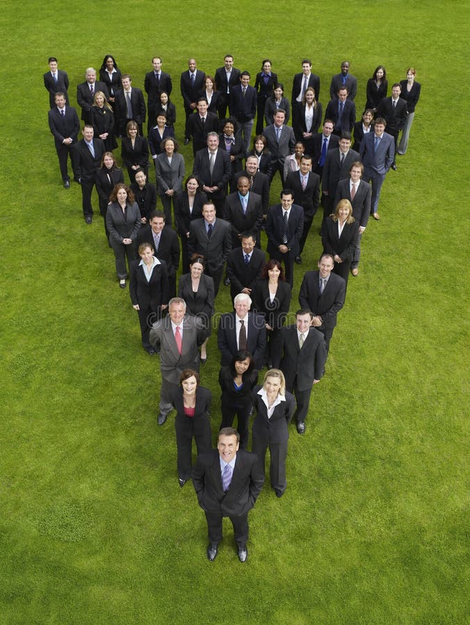 Elevated view of large group of business people standing in triangle formation. Elevated view of large group of business people standing in triangle formation