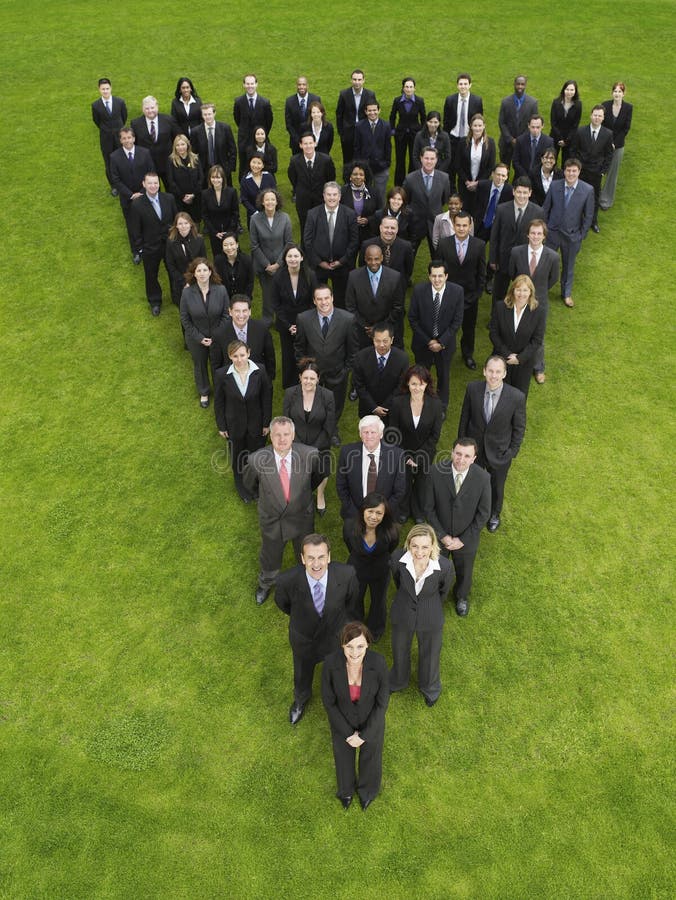 Elevated view of large group of business people standing in triangle formation. Elevated view of large group of business people standing in triangle formation