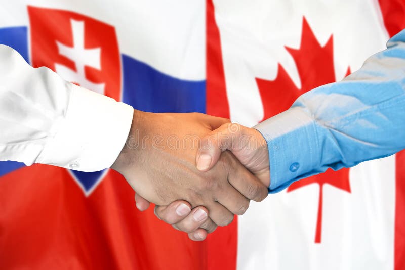 Podanie ruky na pozadí vlajky Slovenska a Kanady
