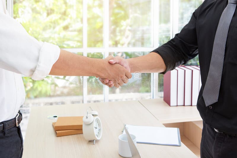 Business handshake. Business associate shaking hands in office. royalty free stock photography Business handshake. Business associate shaking hands in office. royalty free stock photography