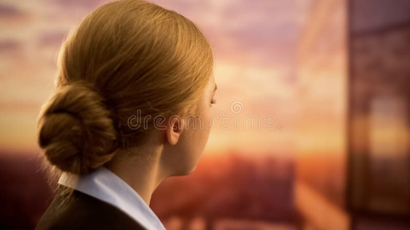 Business lady looking at sunset, dreaming of vacation, lack of time for trips