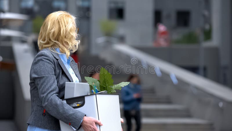 Business lady with stuff box looking at office building, pension unemployment royalty free stock images Business lady with stuff box looking at office building, pension unemployment royalty free stock images