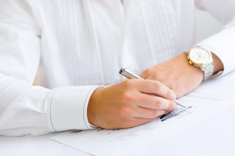 Business man analysing graph and making notes