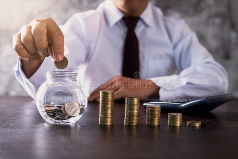 business man or banker put coin in jar and stacked money to save investment, finance and income concept