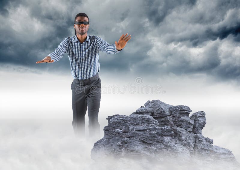 Business man blindfolded on misty mountain peak against storm clouds