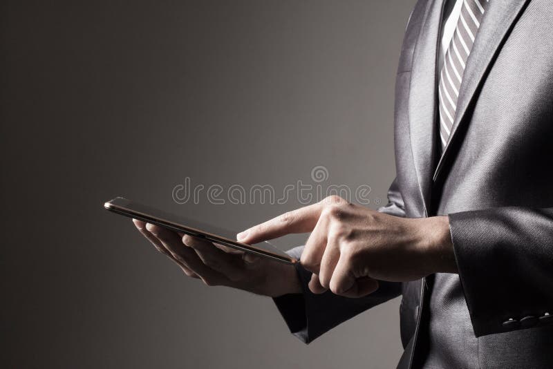 The Business man in Grey suit holding tablet touching social media Technology Concept stock photo The Business man in Grey suit holding tablet touching social media Technology Concept stock photo