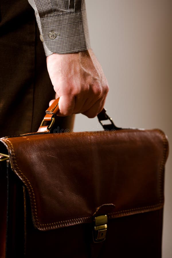 Business man holding elegant brown leather briefcase. Business man holding elegant brown leather briefcase.