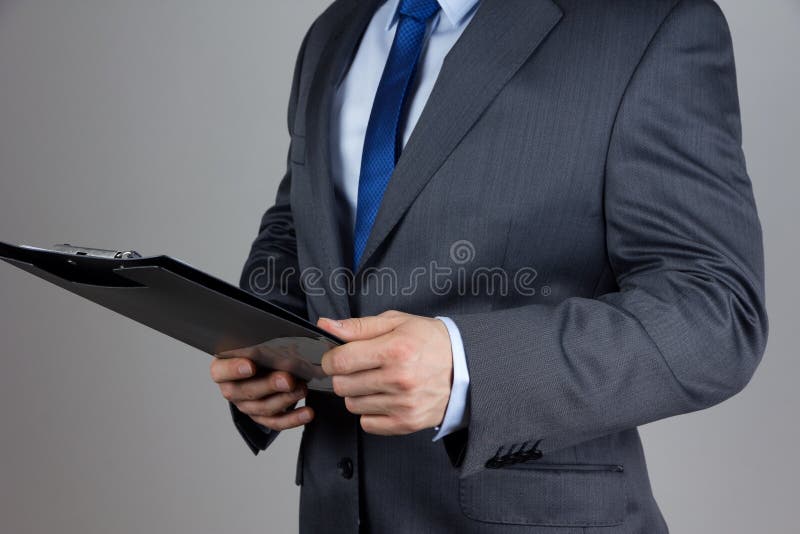 Business man holding folder with documents over grey background