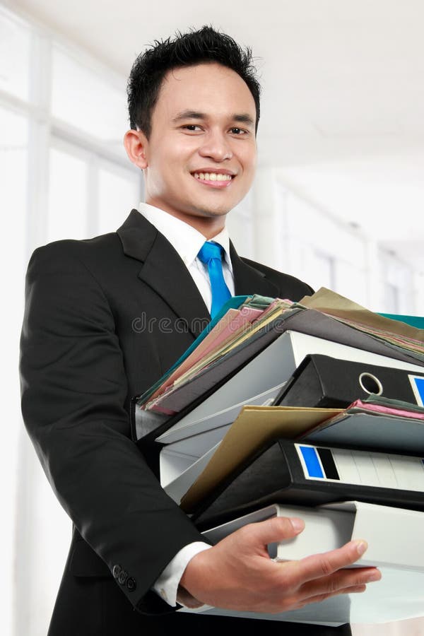 Smiling business man holding stack of files and folders