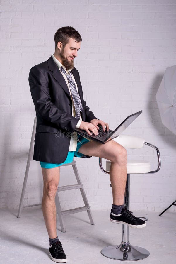 Business man in a jacket and shorts working on the laptop remotely