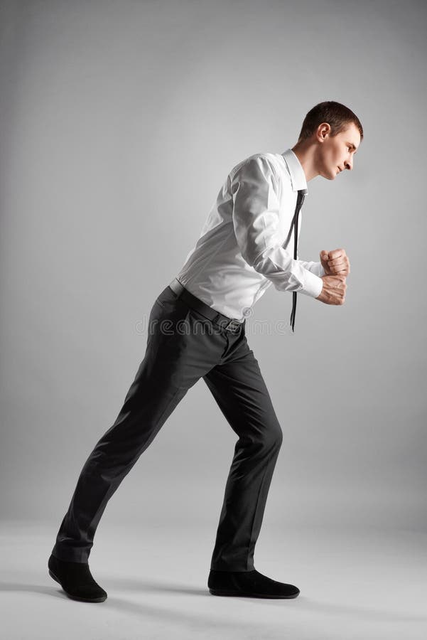 Business man pulling isolated on gray royalty free stock images