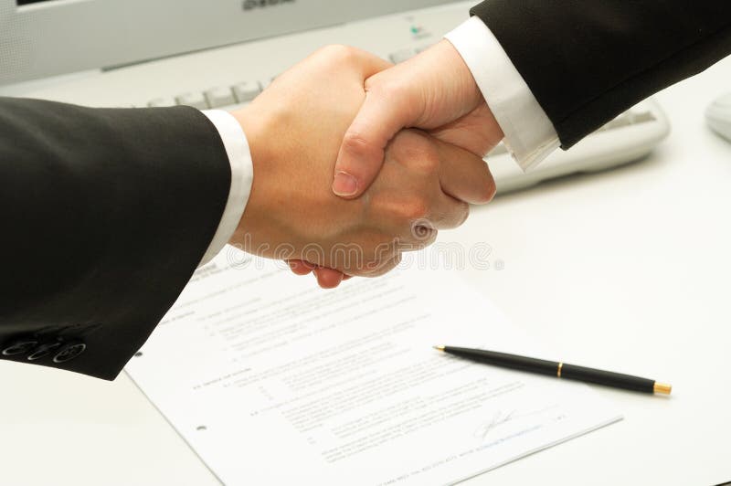 Business man shake hands after signing a contract