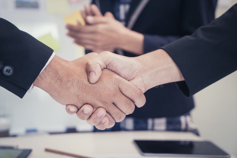 Business man shaking hand with woman clapping stock photo