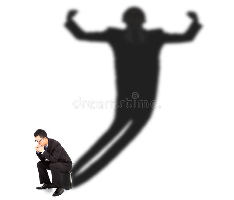 Business man sitting and casting shadow of a strong man