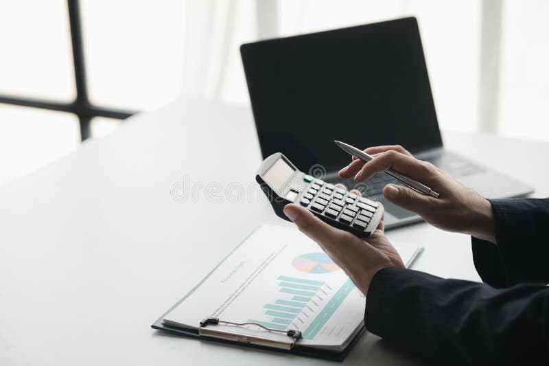 Business Man Using a Calculator To Calculate Numbers on a Company S