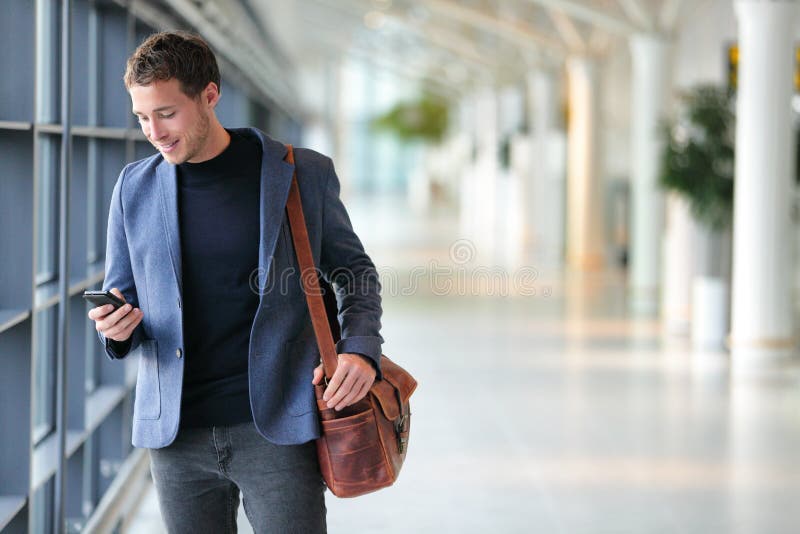 Business man using mobile phone app in airport