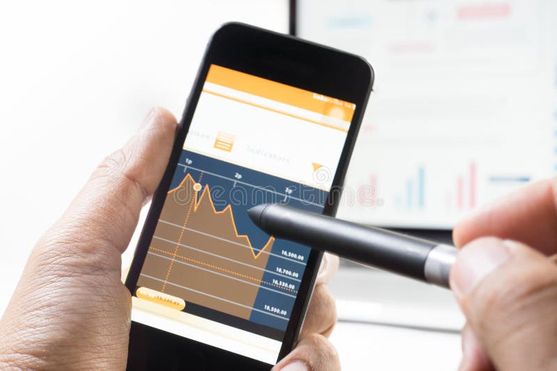 Business man using pen with a mobile phone device and graph royalty free stock photos Business man using pen with a mobile phone device and graph royalty free stock photos
