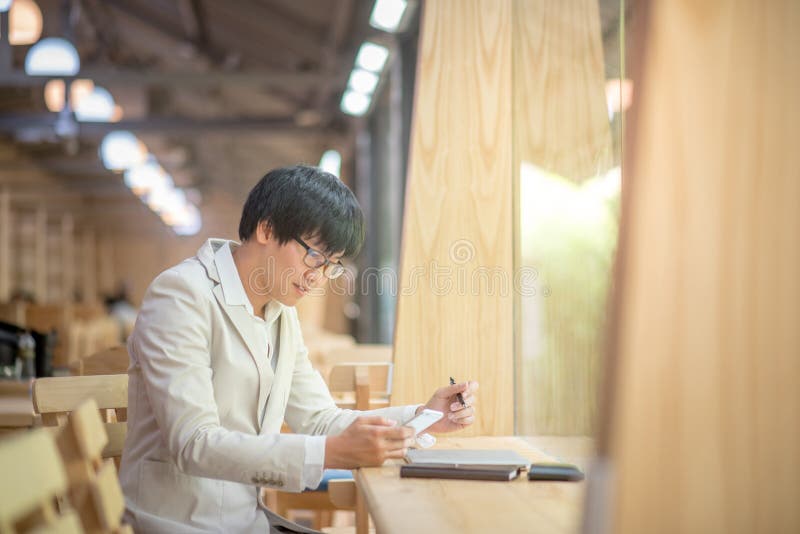 Business man using smartphone and checking his work royalty free stock photo Business man using smartphone and checking his work royalty free stock photo