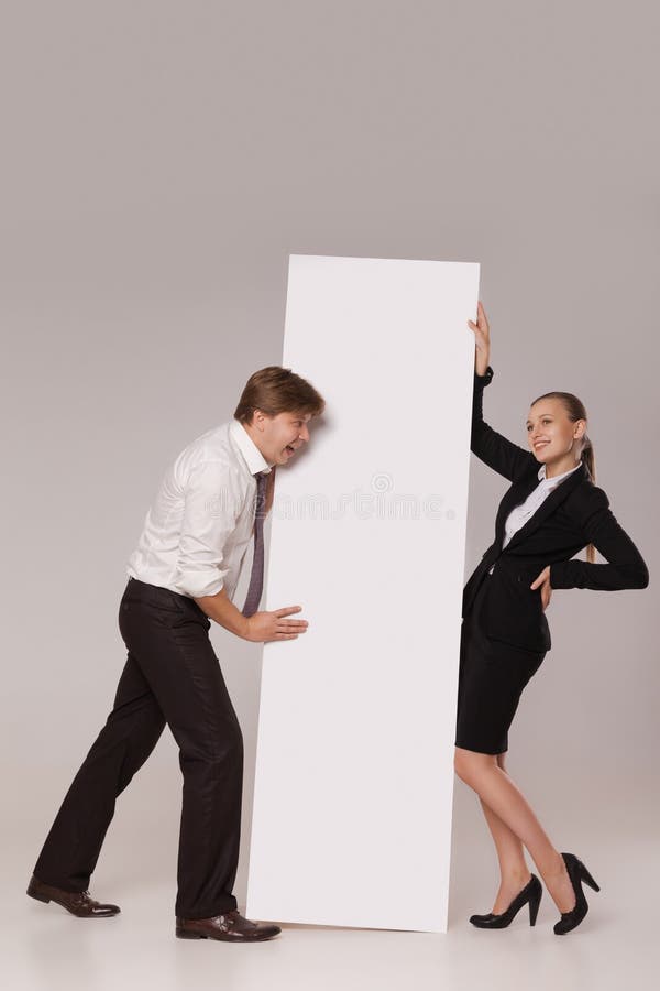 Business man and woman standing over blank banner. 