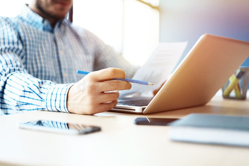 Business man working at office with laptop and documents on his desk