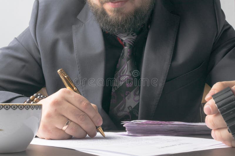 Business man writing a treaty or contract at the table and working on documents in the office,business concept.