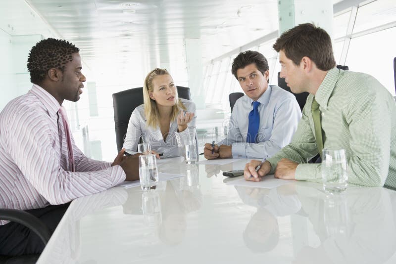 Quattro uomini d'affari di avere un incontro, a discutere in un tavolo da ufficio.