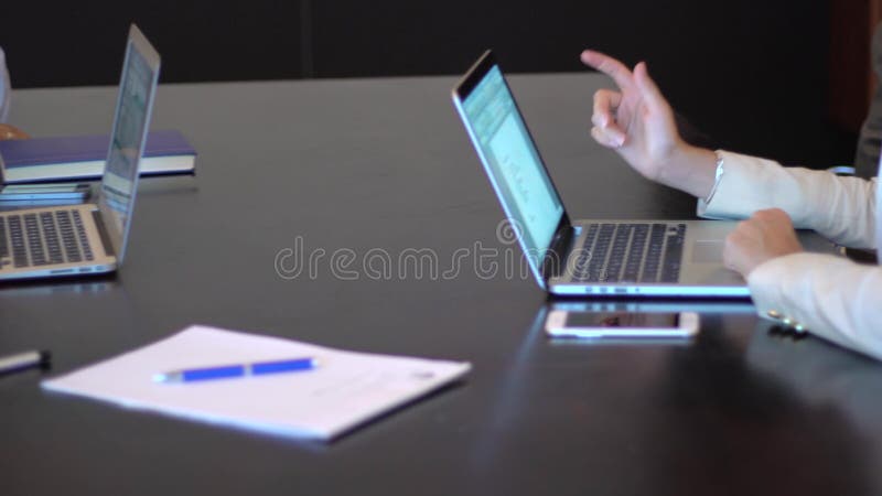 A business meeting hands using a laptop with stats