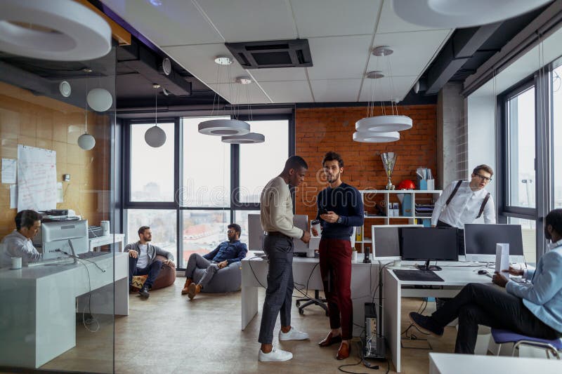 Business men in an open space office interior with a panoramic window, long shot stock photo