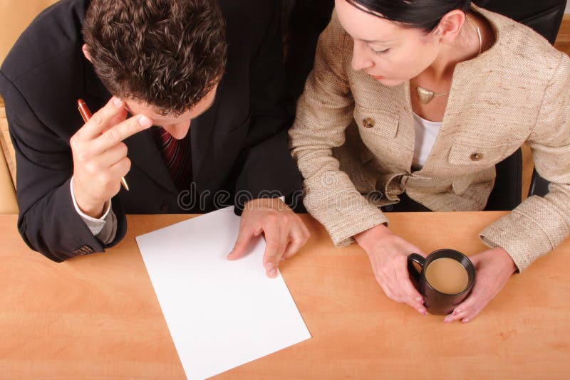 Business-Mann und Frau sitzen am Schreibtisch im Büro, Papier Lesen.