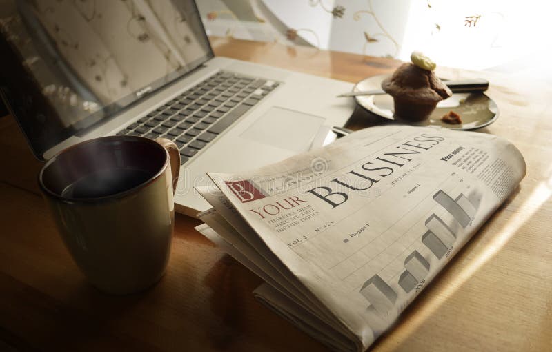 Diario la tienda periódico sobre el desayuno junto a café taza, computadora portátil.