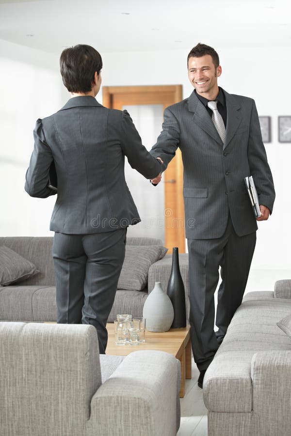 Business meeting at office lobby partners shaking hands. Business meeting at office lobby partners shaking hands.