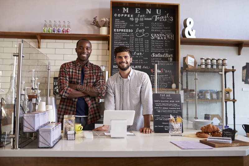 Business partners stand behind the counter at a coffee shop. Business partners stand behind the counter at a coffee shop