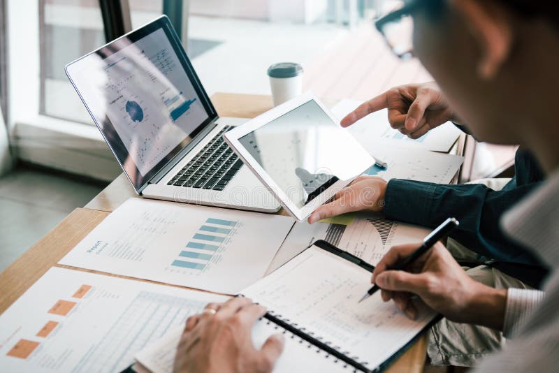 Business partnership coworkers using a tablet to analysis graph company financial budget report and cost work progress and royalty free stock photo