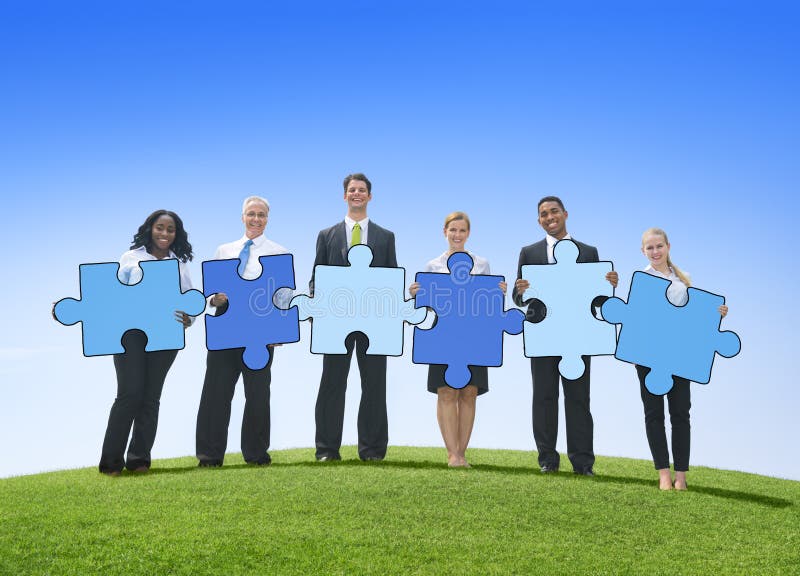 Business People Holding Jigsaw Puzzle Pieces Outdoors royalty free stock images